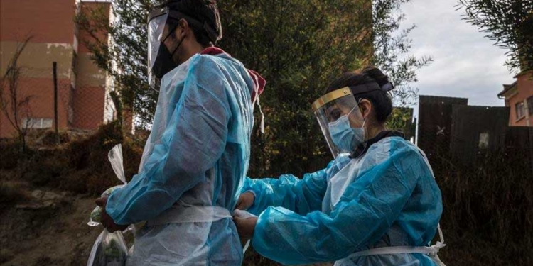 Los trabajadores de la salud preparan sus trajes protectores antes de llevar a cabo un gran operativo de 6 días para detectar casos positivos de COVID-19 casa por casa, en La Paz, Bolivia | Foto: Marcelo Pérez Del Carpio - Agencia Anadolu