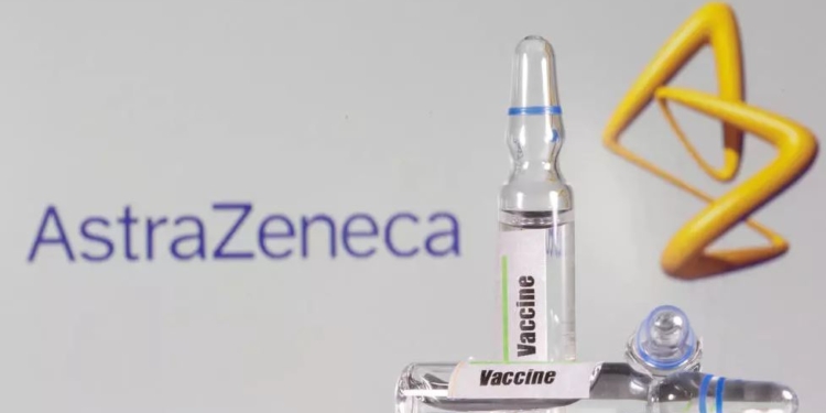 Un tubo de ensayo etiquetado con la vacuna se ve delante del logo de AstraZeneca | Foto Reuters