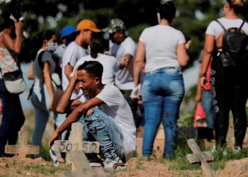 Una familia de venezolanos llora la muerte de su padre por covid-19, durante el entierro en el cementerio de Caju en la zona norte de Río de Janeiro (Brasil). | Foto: EFE