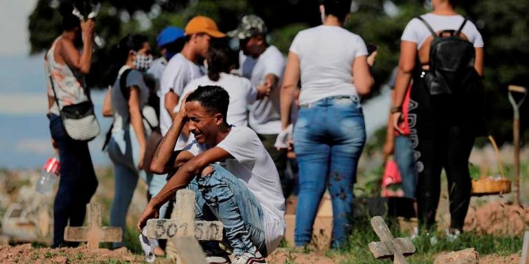 Una familia de venezolanos llora la muerte de su padre por covid-19, durante el entierro en el cementerio de Caju en la zona norte de Río de Janeiro (Brasil). | Foto: EFE