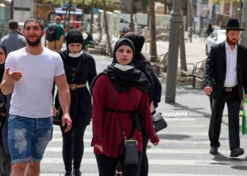 La gente camina en una calle de Jerusalén, el 18 de abril de 2021, después de que las autoridades israelíes anunciaran que las mascarillas para la prevención del COVID-19 ya no eran necesarias al aire libre. Foto: AFP