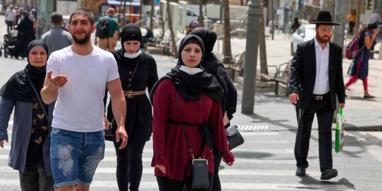La gente camina en una calle de Jerusalén, el 18 de abril de 2021, después de que las autoridades israelíes anunciaran que las mascarillas para la prevención del COVID-19 ya no eran necesarias al aire libre. Foto: AFP