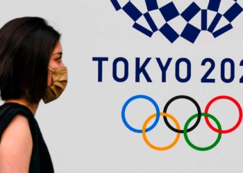 Una mujer pasa junto al emblema de los juegos olímpicos, en una calle de Tokio. /
EFE / KIMIMASA MAYAMA