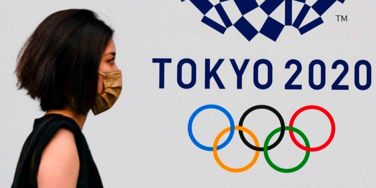 Una mujer pasa junto al emblema de los juegos olímpicos, en una calle de Tokio. /
EFE / KIMIMASA MAYAMA