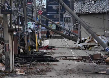Personas caminan junto a restos quemados de estructuras de edificios tras un terremoto en Wajima, prefectura de Ishikawa (Japón). EFE/EPA/Franck Robichon