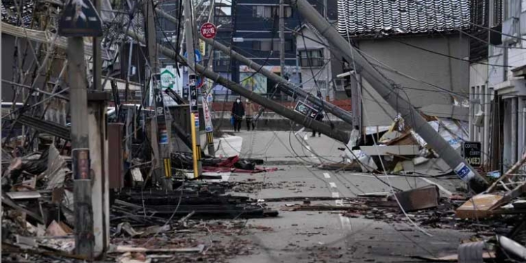 Personas caminan junto a restos quemados de estructuras de edificios tras un terremoto en Wajima, prefectura de Ishikawa (Japón). EFE/EPA/Franck Robichon