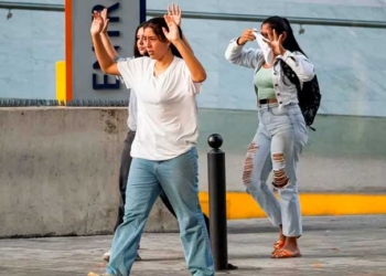 Tres jóvenes avanzan con las manos arriba para evitar ataque de integrantes de la Policía Nacional Bolivariana (PNB) y la Guardia Nacional Bolivariana (GNB) durante enfrentamientos con manifestantes opositores, durante una protesta contra de los resultados de las elecciones presidenciales, en Caracas (Venezuela). EFE/ Ronald Peña R.